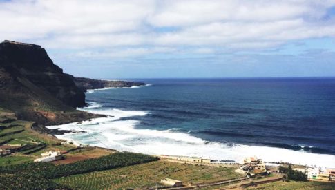 Wave crashing gently on a semi-rocky shoreline