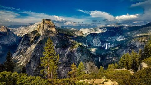 Scenic view of mountains, forest, and sky