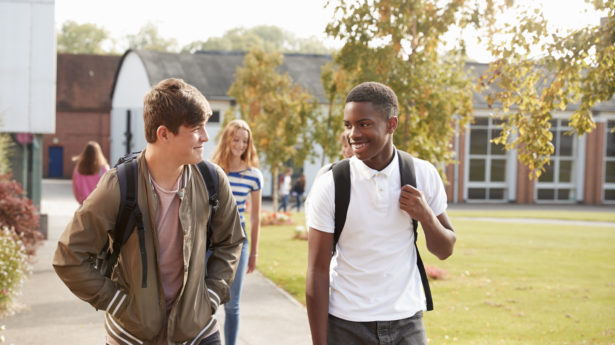 Male Teenage Students Walking Around College Campus Together