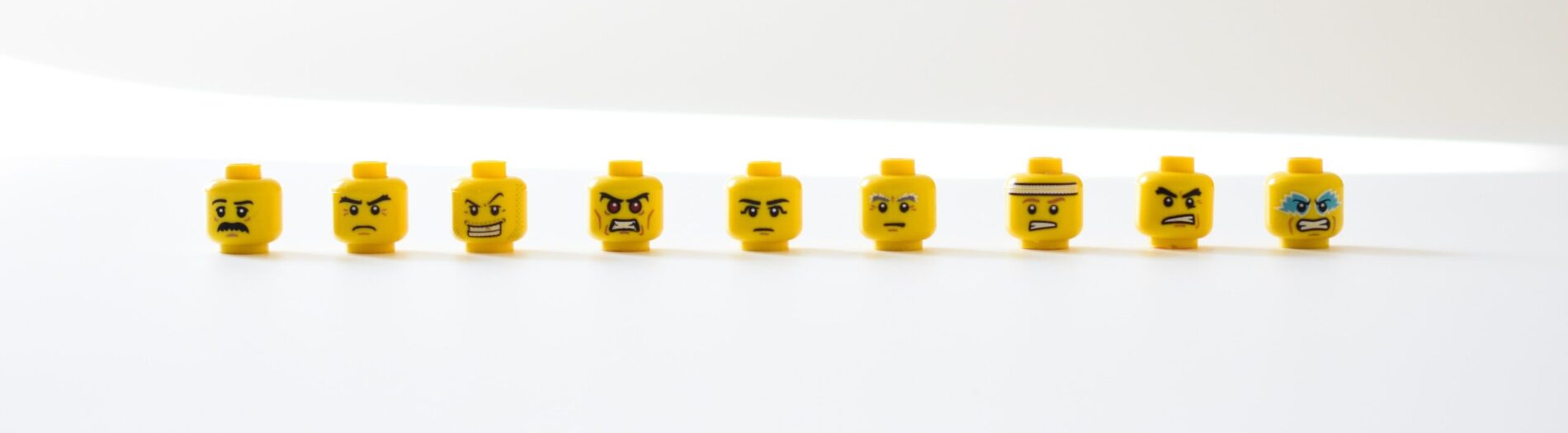 a row of Lego heads with angry faces